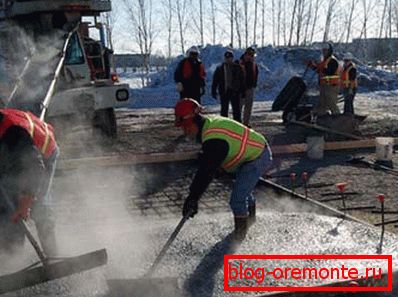Auf dem Foto - der Prozess des Verlegens von vorgeheiztem Beton Auf dem Foto - der Prozess des Verlegens von vorgeheiztem Beton