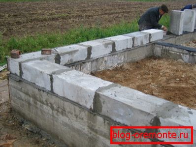 Installation der ersten Schaumblockreihe auf einem Betonfundament Installation der ersten Schaumblockreihe auf einem Betonfundament